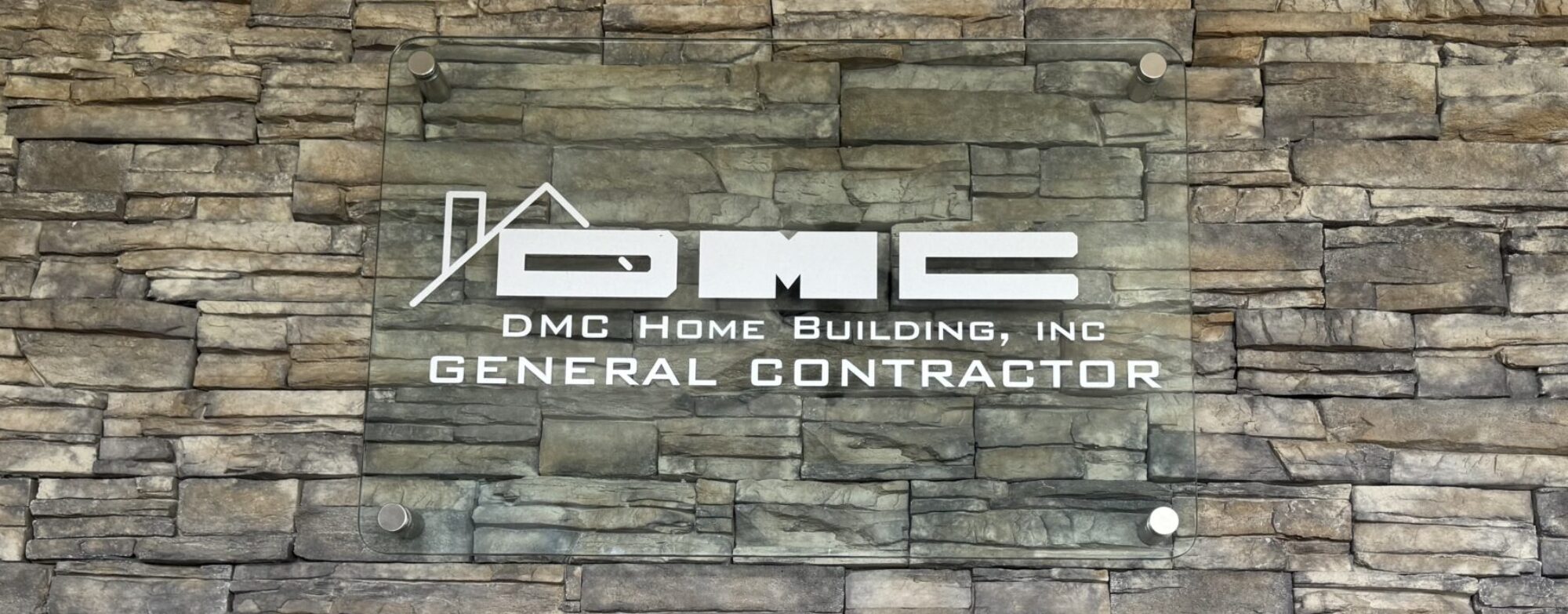 DMC Home Building Inc sign on modern stone facade at our McKinleyville office - General Contractor Humboldt County CA